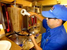 Grill man slicing the famous Gyros at Charcoal Delights Restaurant in Chicago Grill man slicing the famous Gyros at Charcoal Delights Restaurant in Chicago