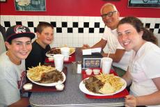 Family feasting on hearty gyros plates at Plush Pup Gyros Restaurant in Norwood Park Family feasting on hearty gyros plates at Plush Pup Gyros Restaurant in Norwood Park